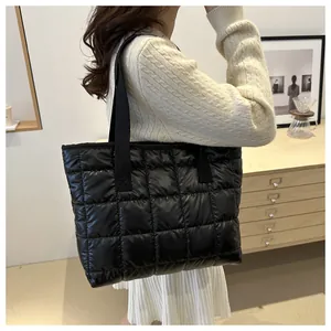 Détail d'un grand sac cabas matelassé noir avec bandoulière pour un usage quotidien