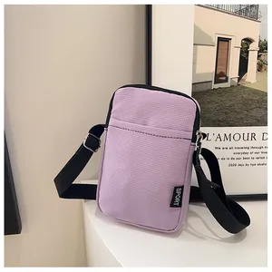 Details der hellvioletten Cord-Handytasche mit schwarzem SPORT-Label und Tragegurt