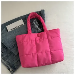 Vue détaillée d'un sac cabas matelassé rose vif avec surpiqûres carrées et fermeture bouton