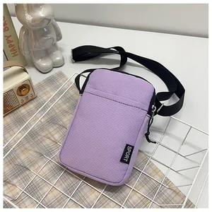 Nahaufnahme der lila Cord-Handytasche mit verstellbarem Gurt und Sport-Webetikett