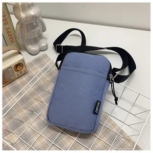 Detail der blauen Handytasche aus Cord mit SPORT-Label und verstellbarem Schultergurt
