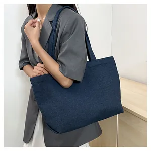 Detail of navy blue denim tote bag showing fabric texture and spacious shoulder strap design