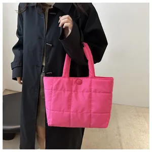 Détail du sac fourre-tout matelassé rose rouge avec texture rembourrée et bouton assorti