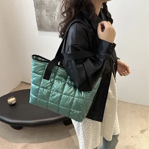 Sac cabas matelassé vert brillant avec large bandoulière noire porté par un mannequin