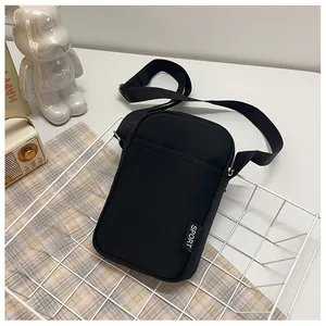 Detail einer schwarzen Nylon-Handytasche mit SPORT-Label in einem weißen Metallkorb