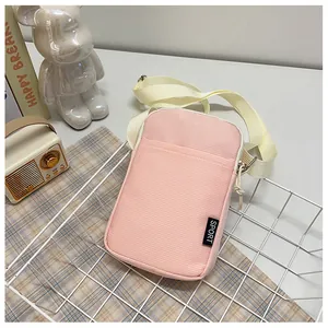 Detailansicht der rosa Cord-Handytasche mit verstellbarem Gurt und Sport-Schriftzug