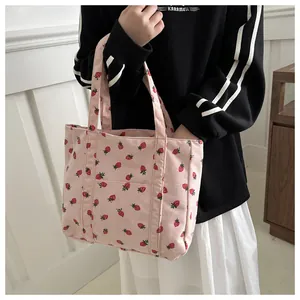 Detail van roze corduroy tote bag met aardbeienprint en open voorvak voor accessoires