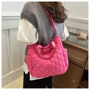 Detailed close-up of pink quilted tote bag showing rhombus stitching and side pockets