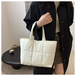 Détail du sac fourre-tout matelassé blanc crème avec fermeture à bouton sécurisée