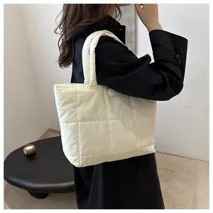Détail du sac fourre-tout matelassé beige avec surpiqûres carrées et bandoulière