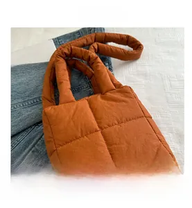 Vue détaillée du sac cabas matelassé orange sur denim avec motifs à carreaux surpiqués