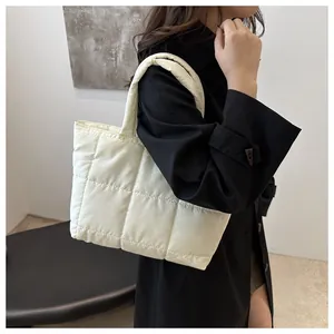 Détail du sac cabas matelassé crème avec un design rembourré moderne et une bandoulière