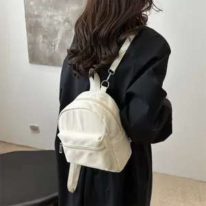 Mini mochila de mujer crema en nailon con correas ajustables y bolsillo frontal