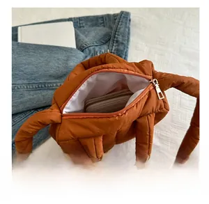 Vue détaillée de l'intérieur spacieux d'un sac matelassé marron avec un long portefeuille