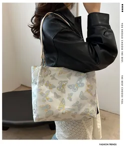 Detail of a white tote bag with butterfly prints showing spacious capacity on a model