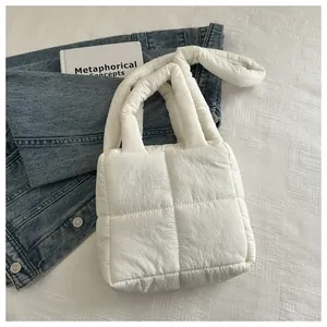Gros plan du sac cabas matelassé blanc avec texture en points de croix et sangle douce