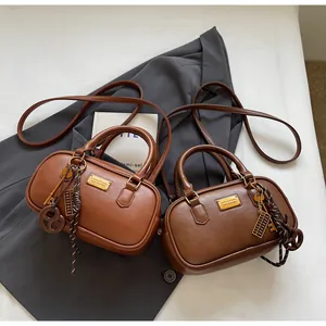 Detailansicht von zwei Vintage Boston Handtaschen in Brauntönen mit goldenen Beschlägen