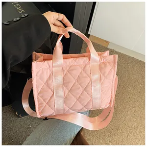 Pink quilted puffer bag with crossbody strap and handle shown in a fashion lifestyle setting