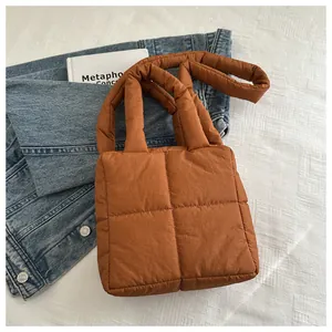 Gros plan détaillé d'un sac à main matelassé caramel avec rembourrage doux et anses