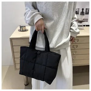 Détail du grand sac cabas en nylon matelassé noir avec coutures carrées et bouton