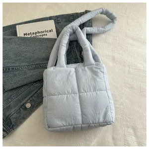 Détail du sac cabas matelassé bleu clair avec anses épaisses et texture en nylon doux