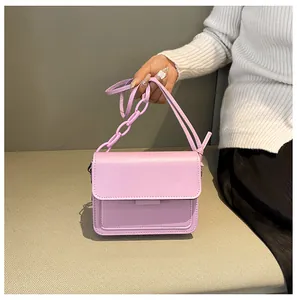 Detail of lavender mini square bag featuring chic acrylic chain and smooth PU leather