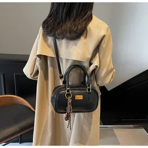 Detail einer schwarzen matten Leder-Bowlingtasche mit goldenen Beschlägen und Anhänger