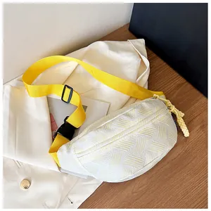 Detailansicht der weißen Brusttasche mit gelbem Gurt und geflochtenem Reißverschluss
