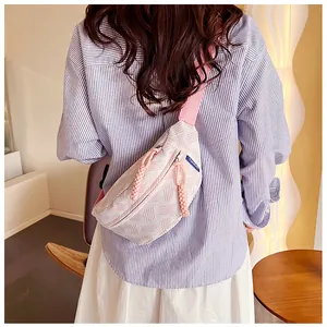 Mädchen mit einer süßen rosa-weißen gestrickten Brusttasche in gemütlicher Umgebung