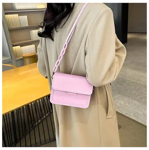 Detail view of pink rectangular crossbody bag with stylish resin chain strap and fine stitching