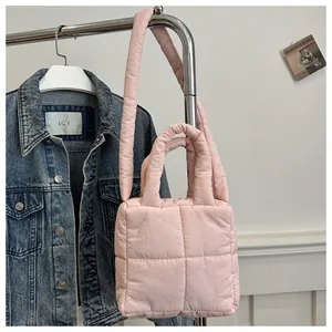 Détail d'un sac bandoulière matelassé rose avec rembourrage moelleux et motif à carreaux