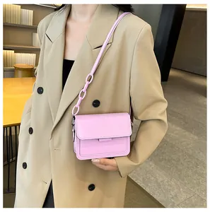 Detail of pink crossbody bag featuring a smooth texture and large resin chain strap