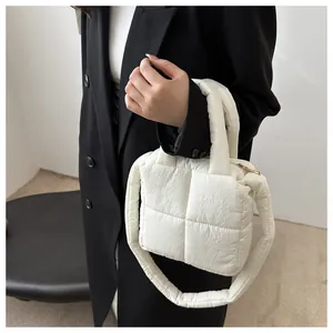 Détail du sac à main matelassé blanc présentant une texture rembourrée et un design épuré