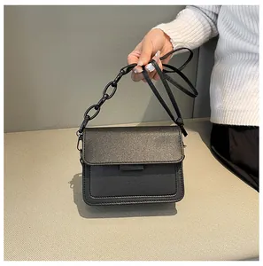 Detail of black matte square shoulder bag with unique chunky chain strap and flap closure