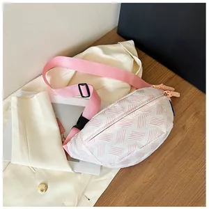 Detail der gewebten Brusttasche mit rosa Gurt und Schnalle auf einem Holztisch