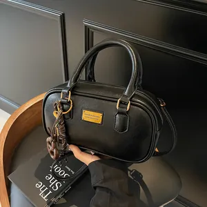 Schwarze Retro-Handtasche aus Leder im Bowling-Stil mit goldenem Metallemblem