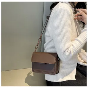 Deep brown retro crossbody bag with resin chain strap shown on a white knit sweater