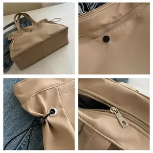 Detail view of beige nylon tote bag showing snap closure, drawstring and inner zipper