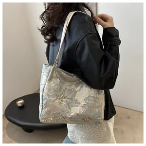 Close-up of the vintage floral jacquard fabric and beige leather strap on this tote bag