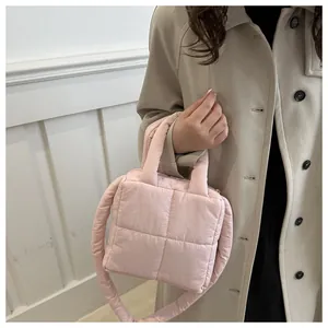 Gros plan détaillé du sac matelassé rose avec poignées supérieures et bandoulière assortie