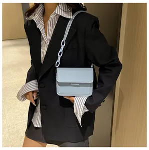 Detail of light blue crossbody bag with chunky resin chain strap and matte PU leather texture