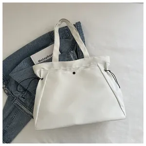 Detailed view of white nylon tote bag with black drawstring and metallic snap button