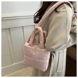Détail du sac matelassé rose pâle montrant la texture douce et la bandoulière sur le mannequin