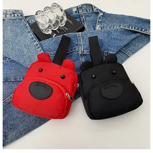Detalle de mini bolsos de lona con forma de oso lindo en rojo y negro con cremallera