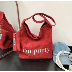 Detail der roten Cord-Einkaufstasche mit Buchstabendruck und Mini-Anhängertasche
