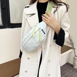 Weiße geometrisch strukturierte Bauchtasche mit grünem Gurt und gelben Zippern