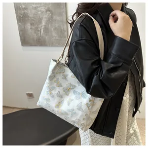 Close-up of intricate butterfly embroidery on casual cream tote bag for college commute