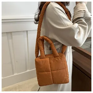 Gros plan du sac matelassé caramel avec poignées rembourrées et coutures carrées