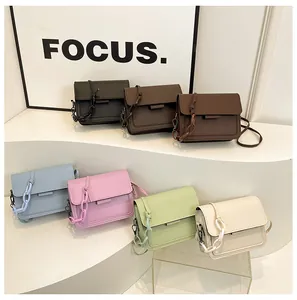 Detail showing various colors of mini square shoulder bags with chunky chain accents
