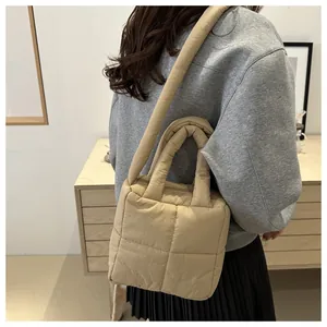 Gros plan du sac cabas matelassé beige avec des bretelles rembourrées épaisses